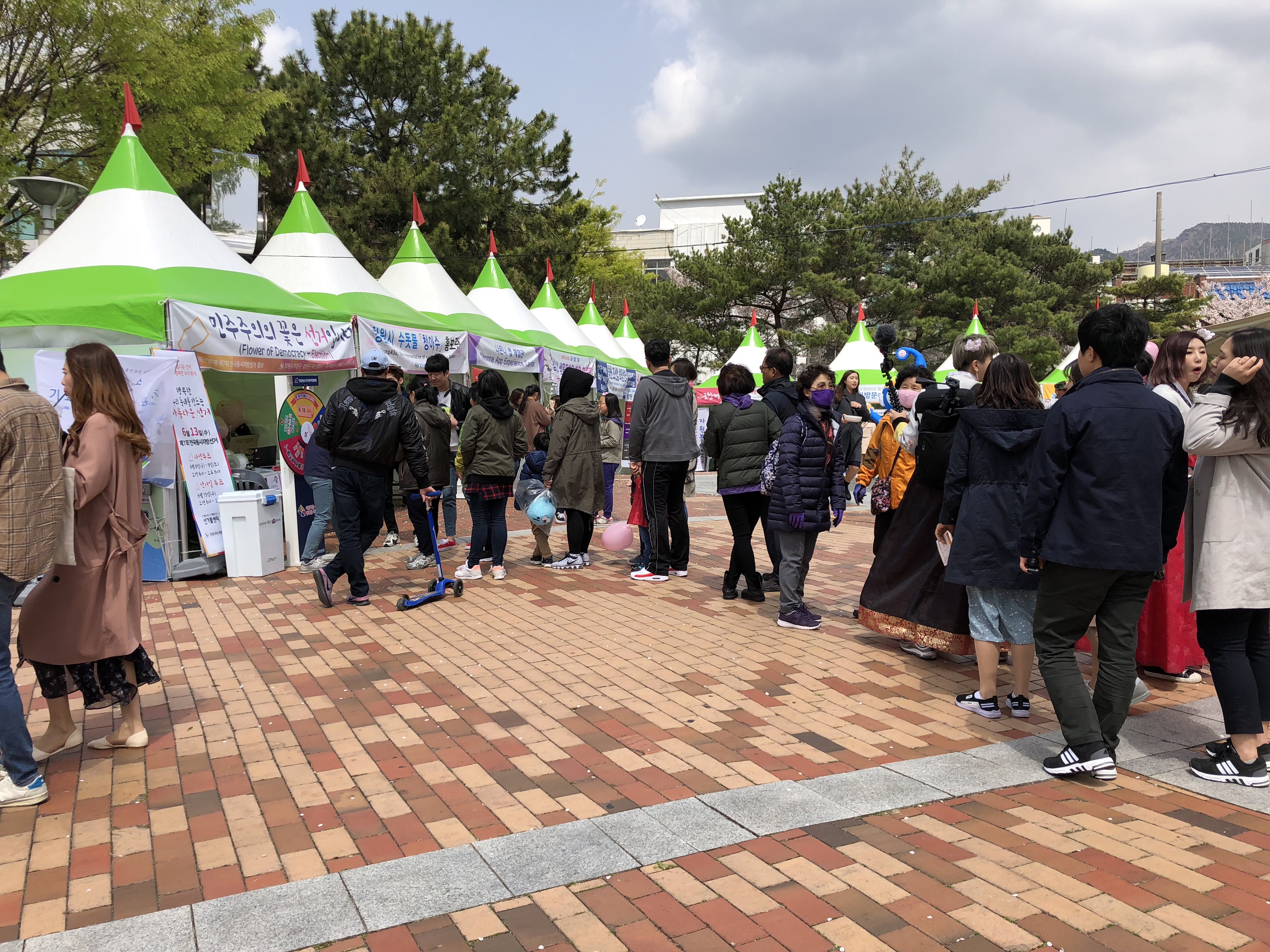 진해군항제에서 회원구선거관리위원회가 운영하는 홍보부스 다트판 이벤트에 참여하기 위해 줄을 서 있는 시민들 모습입니다