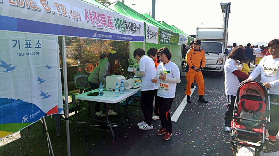 제28회 3.15마라톤대회에 참가한 시민이 선거관리위원회 홍보부스에서 사전투표체험을 하고 있다.