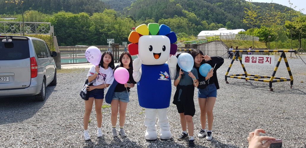 위원회 홍보 탈 인형인 참참이와 아이들이 사진을 찍으며 포즈를 취하고 있습니다