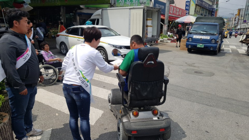 사진2) 전통시장을 방문한 손님들에게 홍보리플릿을 전달하는 사진