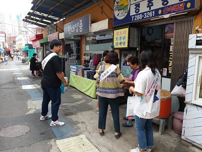북구위원회와 동구위원회가 합동으로 신전시장 내 상인들에게 기부행위 제한 규정을 안내하는 장면