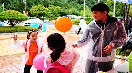 완주 와일드푸드축제를 방문한 어린아이들에게 '민주주의의 꽃은 선거입니다. 아름다운 선거, 행복한 대한민국'이 적힌 풍선을 나눠주는 모습