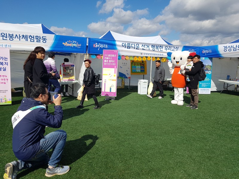위원회 캐릭터와 함께 기념사진을 촬영하는 가족의 모습입니다