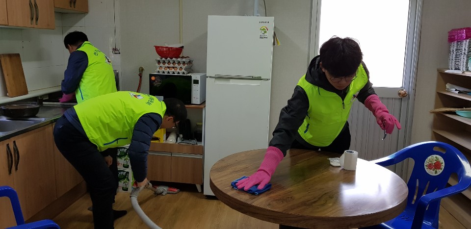 울진군선관위 직원과 공정선거지원단이 마을회관 주방을 청소하는 모습입니다.